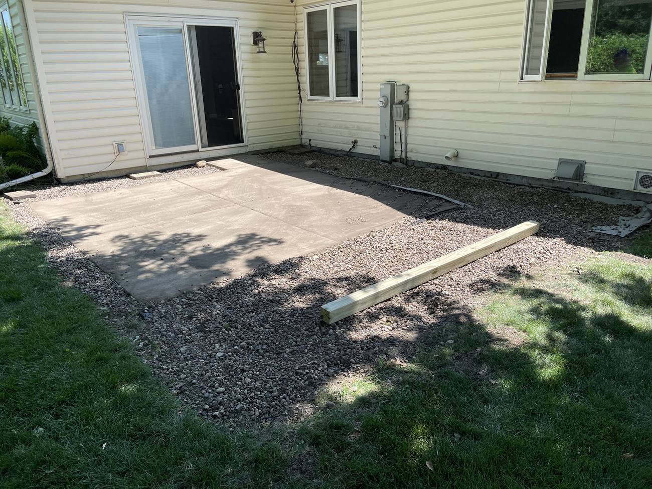 Backyard before deck construction with old concrete patio slab and gravel base, Madison WI