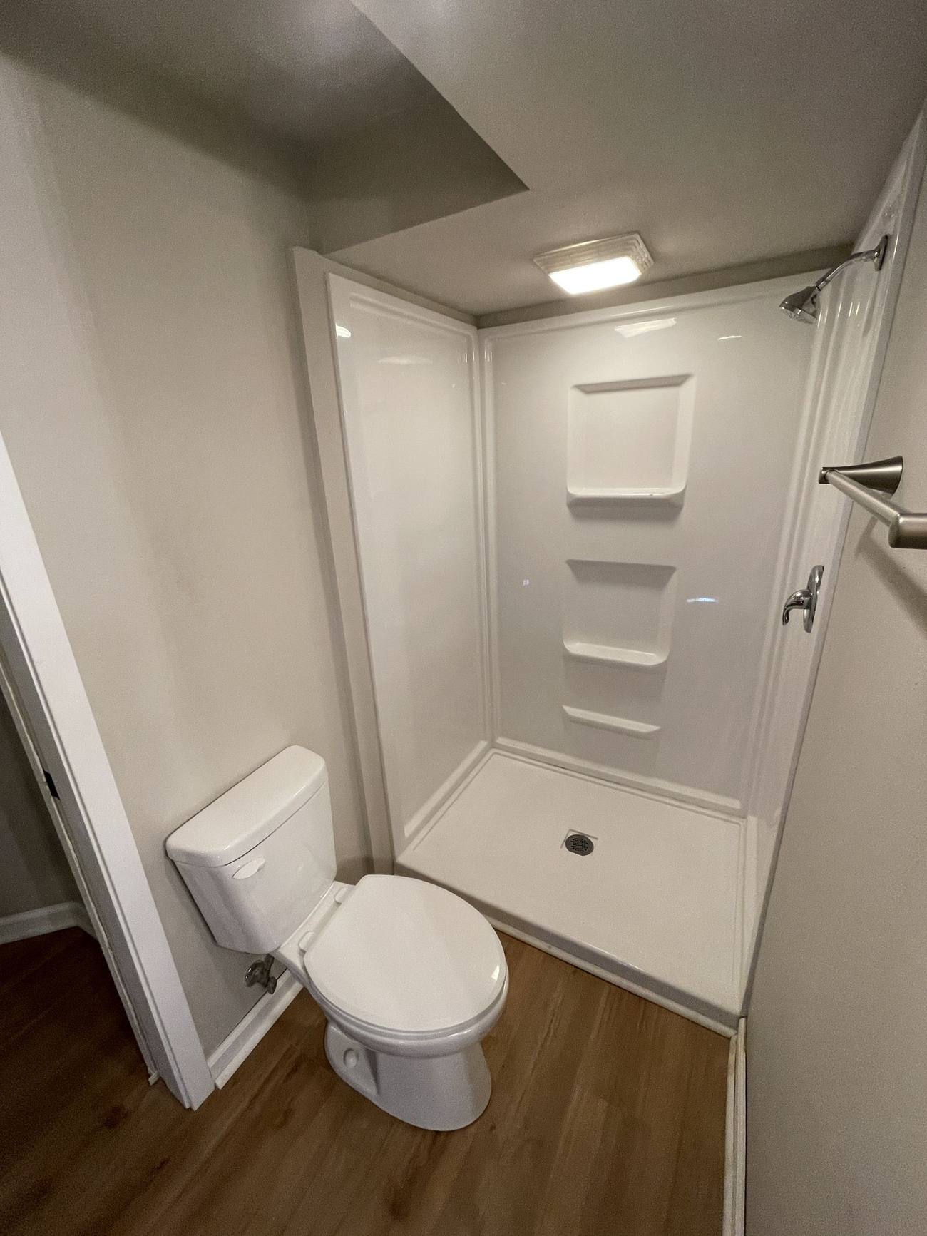 Basement bathroom before remodel with basic acrylic shower stall, Madison WI